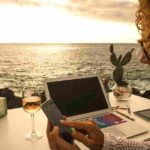 a woman using a laptop and a phone