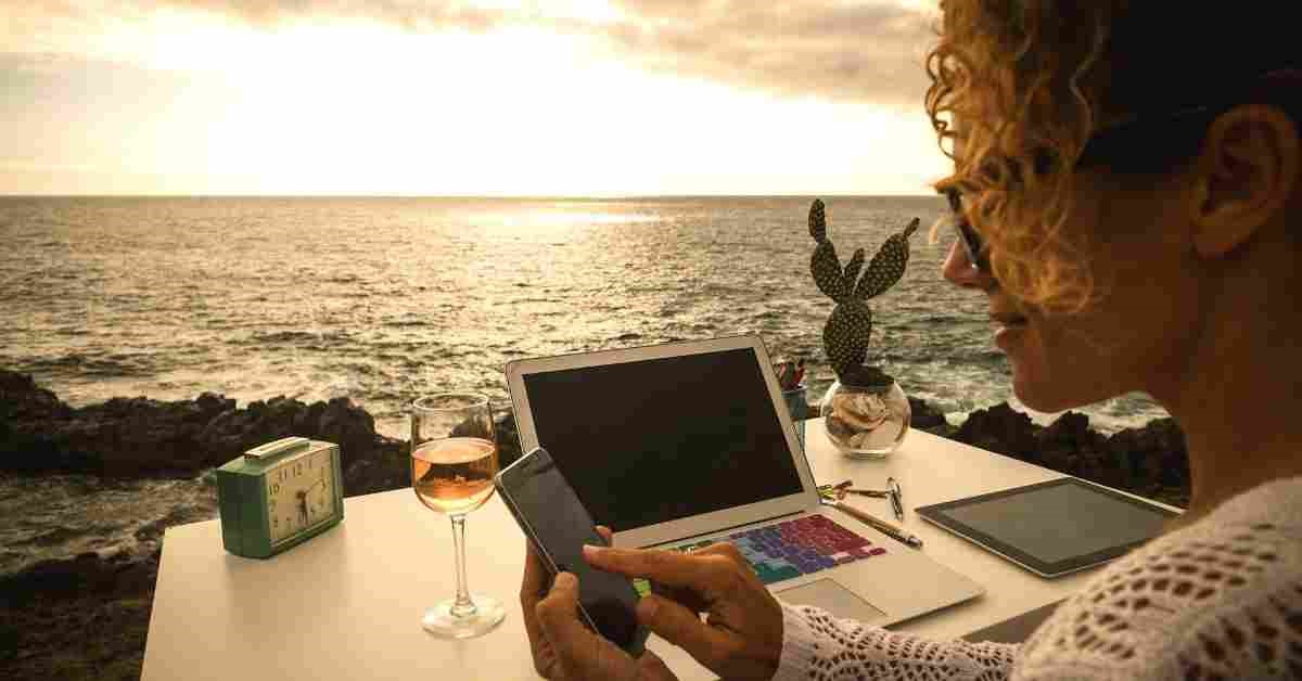 a woman using a laptop and a phone